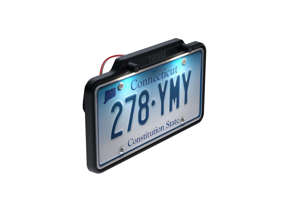 Thule license plate holder illuminated at night showing clear plate visibility