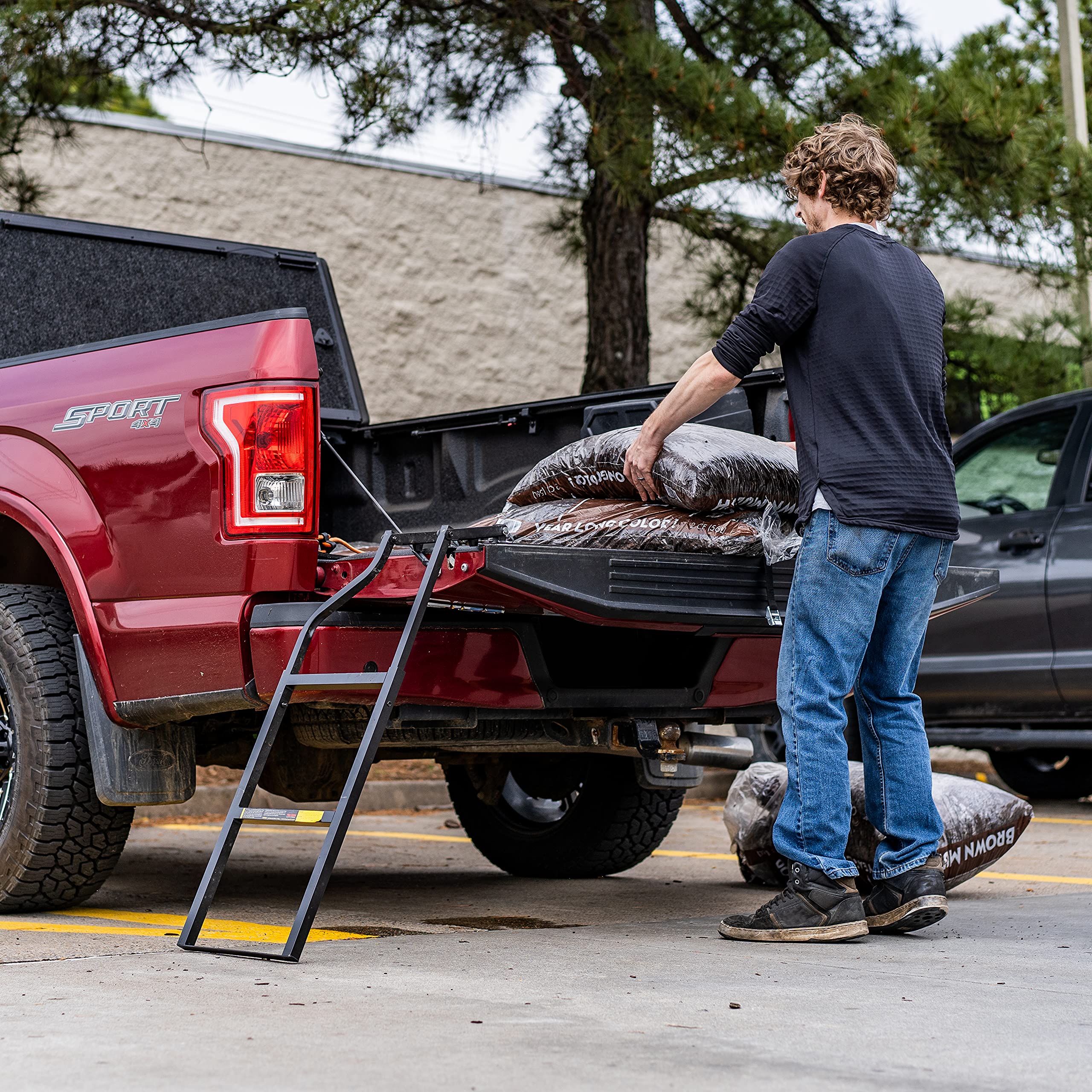 Traxion ladder in use with person stepping into truck bed for safer access