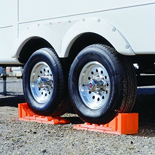Tri-Lynx Stop 'N Chock positioned under RV wheel demonstrating secure chocking benefit