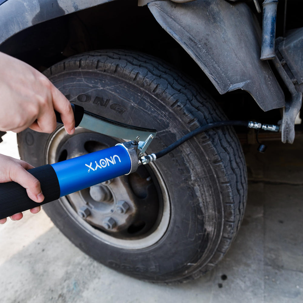 UNOYX grease gun held in hand to show scale and easy handheld operation