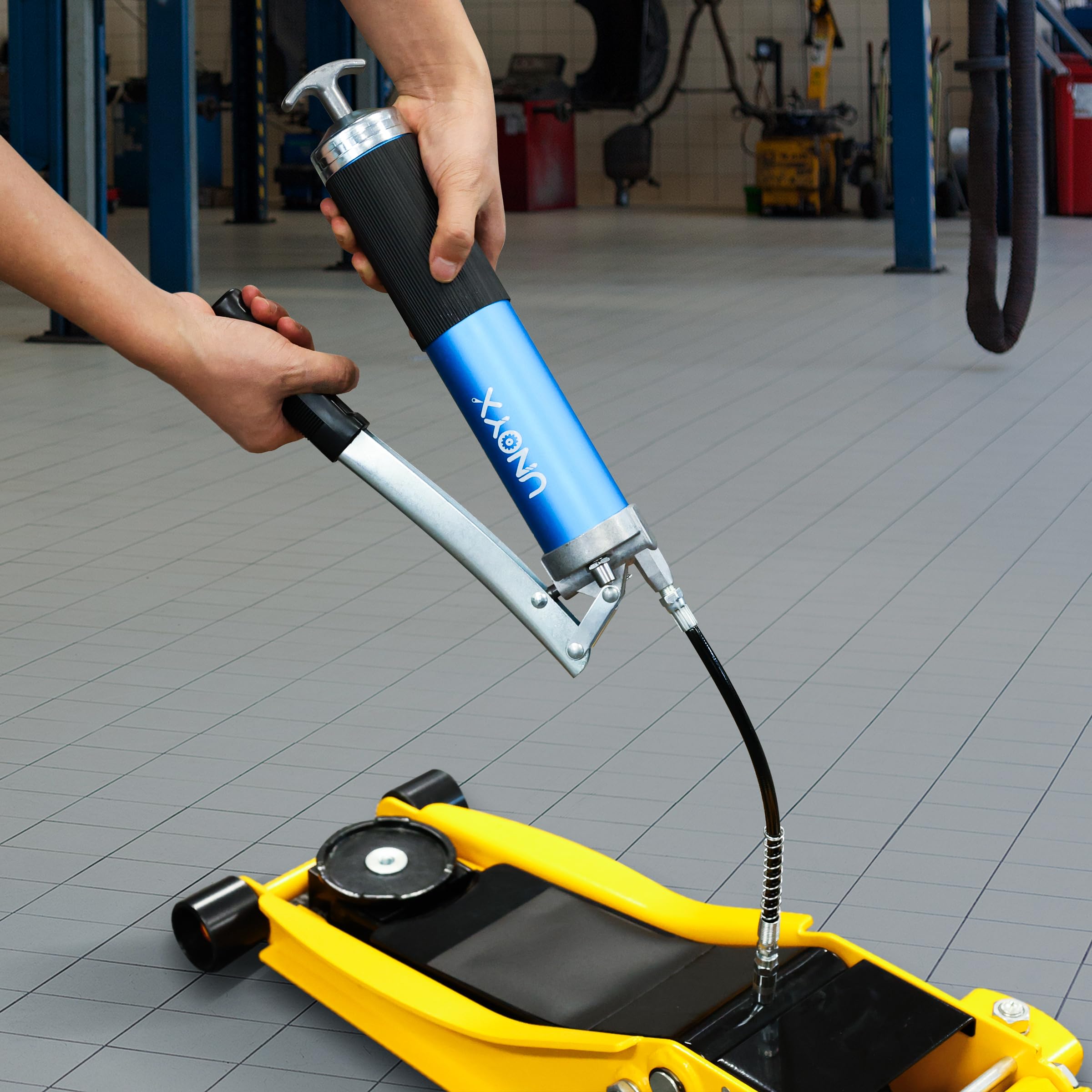 UNOYX grease gun on workshop bench next to tools demonstrating professional use